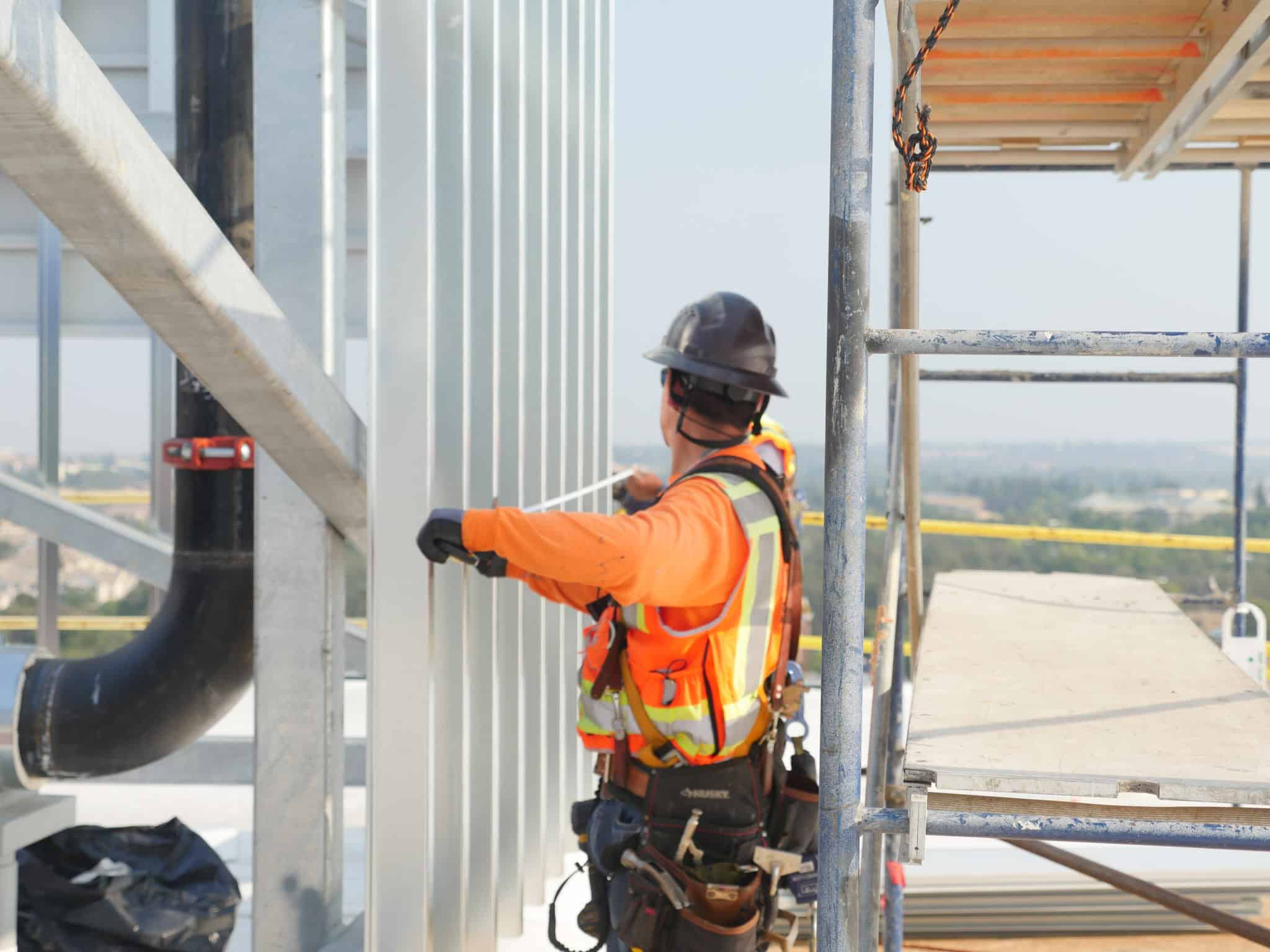 Roofing worker using a measuring tape